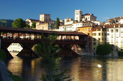 Bridge over river in city against clear sky