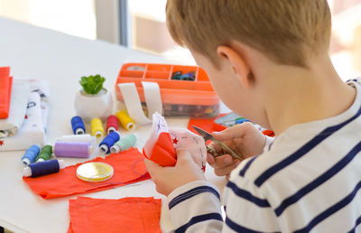 Close-up of a beautiful 9-year-old caucasian boy who studies to sew, additional education, leisure.