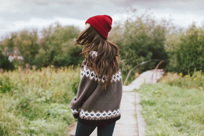 Rear view of woman standing on boardwalk