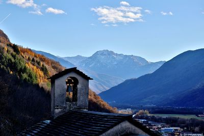 House amidst mountains against sky