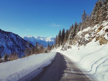 Road amidst snowcapped mountains against sky