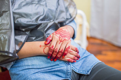 Midsection of man with woman sitting on floor