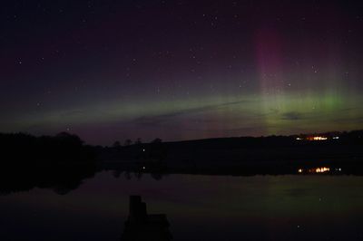 Scenic view of lake against sky at night