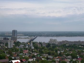 High angle view of buildings and sea against sky