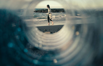 Reflection of woman walking in water