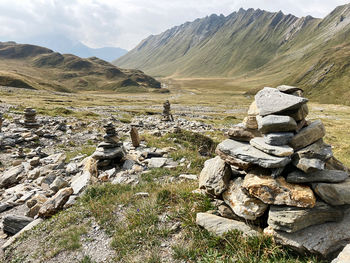 Scenic view of rocky mountains against sky, rock cairns, find your way, passo della greina 