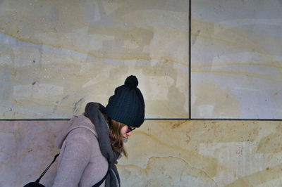 Portrait of woman standing against wall