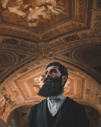 Low angle view of young man standing in temple
