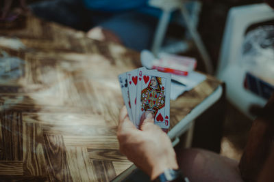 Cropped hand of man playing cards