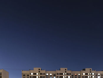 Low angle view of buildings against clear sky at night