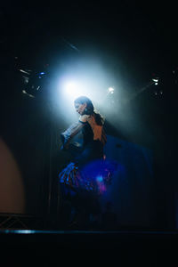 Reflection of young woman on illuminated stage at night