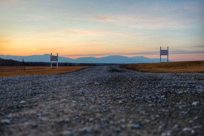 Surface level of road against sky during sunset