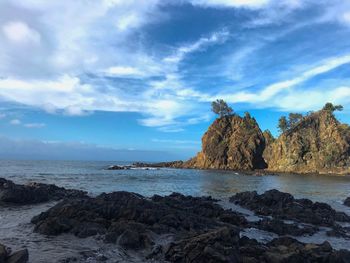 Rocks on beach against sky