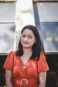 Portrait of smiling young woman standing in city