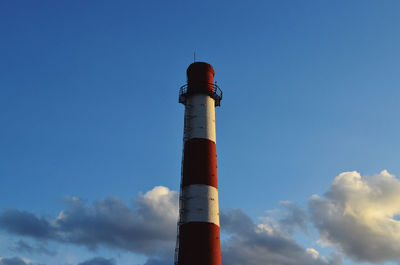 Low angle view of lighthouse by building against sky