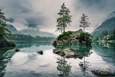 Cloudy sky over foggy mountains and lake, hintersee, ramsau, bavaria, germany