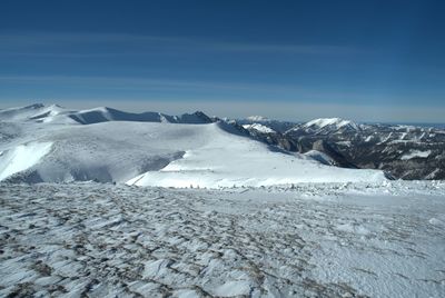 Scenic view of snowcapped mountains against blue sky