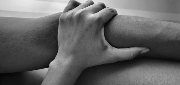 Low section of woman relaxing on bed