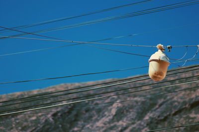 Low angle view of power lines against clear blue sky
