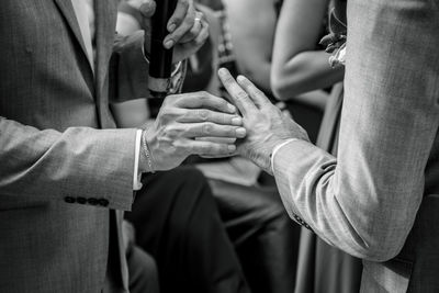 Midsection of gay couple during wedding ceremony