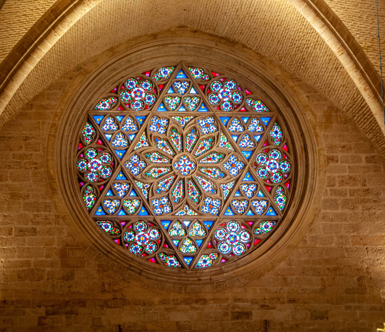 indoors, architecture, built structure, stained glass, pattern, no people, art and craft, window, place of worship, design, arch, glass, low angle view, building, glass - material, creativity, religion, ceiling, shape, belief, ornate, floral pattern, directly below, architecture and art, cupola