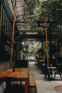 Empty chairs and tables in cafe against building