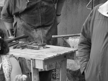 Midsection of man working on work bench at workshop