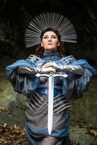 Portrait of a young woman  medieval knight standing with a sword fantasy cosplay
