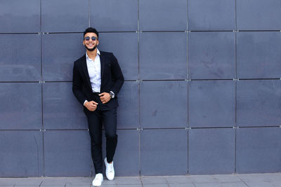 Portrait of businessman standing against wall