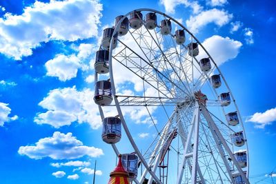 Low angle view of ferris wheel against cloudy sky