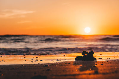 Close-up of orange on beach against sky during sunset
