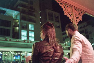 Couple kissing in illuminated city at night