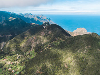 Scenic view of sea and mountains against sky