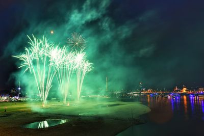 Firework display over river at night