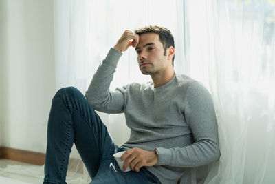 Young man looking away while sitting