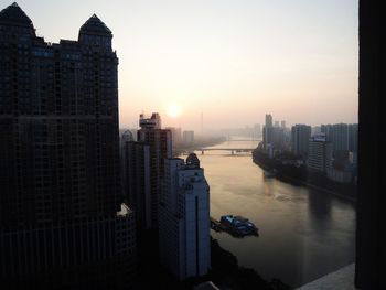 Buildings in city against sky during sunset