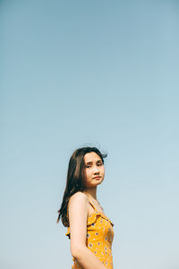 Portrait of woman standing against sky