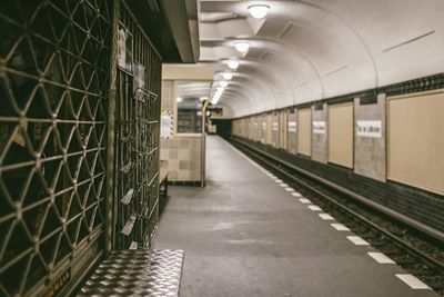 Empty walkway in illuminated city