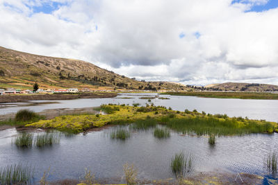 Scenic view of lake and mountains against sky