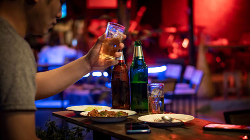 Close-up of hand holding wine bottles