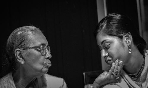 Loving senior woman touching granddaughter at home