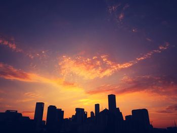 Silhouette buildings against sky during sunset