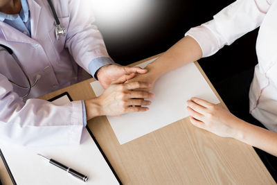 Close-up of people working on table