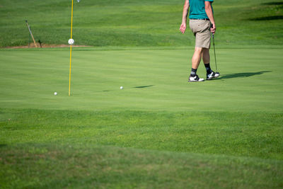 Low section of man playing with ball on grass