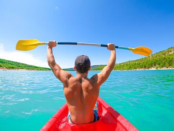 Rear view of man in boat in sea