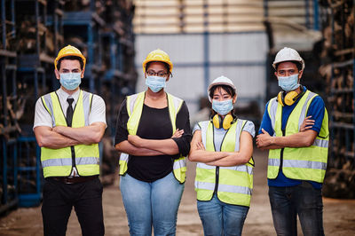 Confident pose of the team engineer wear mask while standing with his arms crossed