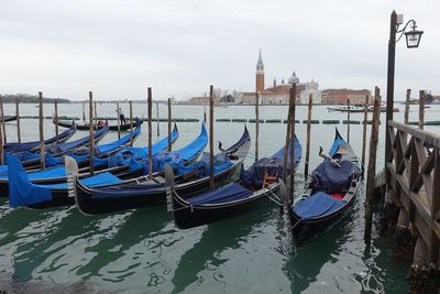 Gondolas moored on grand canal against clear sky