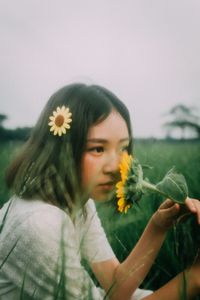 Midsection of girl holding flowering plant