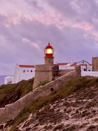 Low angle view of lighthouse against buildings