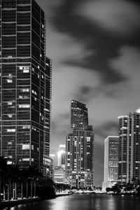 Illuminated buildings in city against sky at night